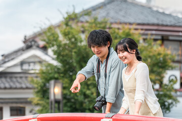 国内旅行で城下町を街歩き・観光ツアーをする若い夫婦・カップル
