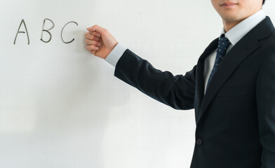 セミナー・研修・勉強会・講義・塾でホワイトボードに書いて会議する教師・講師・ビジネスマン
