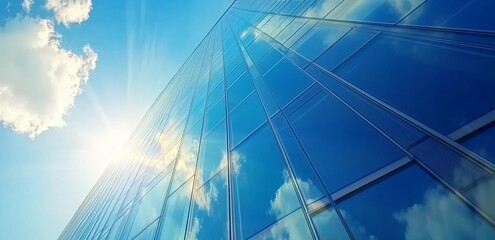 Fototapeta premium Abstract Architectural Perspective of Modern Glass Skyscraper Reflecting Bright Sunlight and Clouds