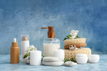Composition with different cosmetic products, spa accessories and flowers on color grunge background
