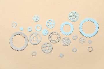 Different paper gears on beige background
