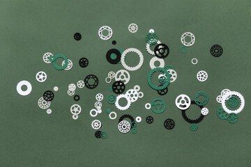 Different paper gears on green background