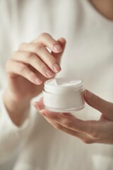 a woman holding cosmetics in a sunny space