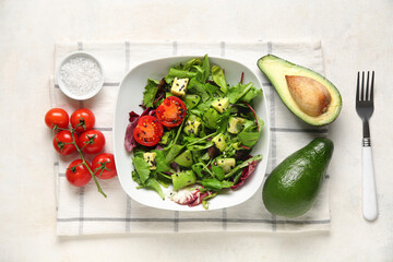 Bowl of tasty avocado salad with cherry tomatoes and sesame seeds on white background