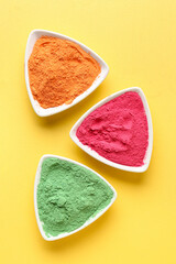 Plates with color powder pigments on yellow background