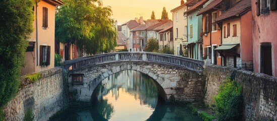 Picturesque stone bridge over tranquil canal in charming European town at sunset.