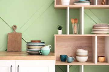 Interior of stylish kitchen with clean dishes on shelves and counter