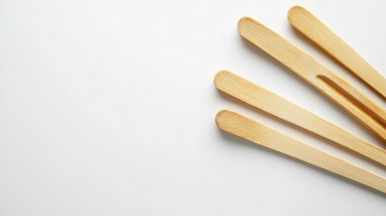 Obraz premium A set of wooden sticks arranged on a clean surface for various uses.