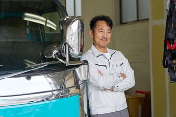 トラックの横に立つ作業服を着た男性のポートレート