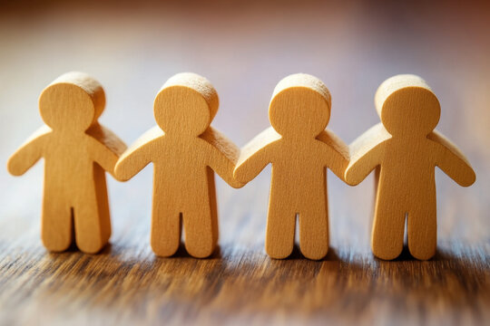 Wooden figures representing teamwork and collaboration, lined up together, symbolizing unity and support in professional environment