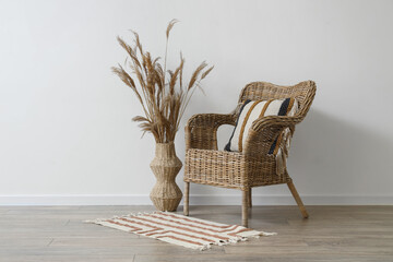 Interior of stylish living room with cozy wicker armchair and pampas grass