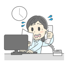 デスクトップパソコンの前で忙しく仕事するスーツの女性