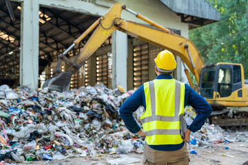 Recycling facility with an engineer standing beside a loader machine, laptop open and monitoring...