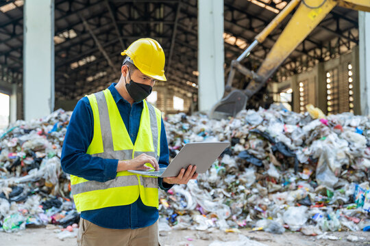 An Engineer monitoring operational efficiency at a recycling facility, data-driven software displayed on a laptop, machines running in sync in waste separation plant.