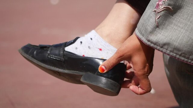 Woman's foot in black shoes and white socks