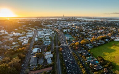 Auckland, New Zealand, highway traffic at sunset. Busy highway, cars, and city buildings. Golden hour light. Newmarket, Auckland, New Zealand