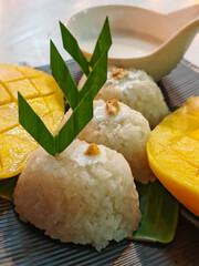 Pulut Mangga or mango sticky rice, a traditional Thai dessert made with glutinous rice, fresh mango and coconut milk. Selective focus.