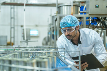 Professional closely examining production materials on a conveyor system, representing dedication...