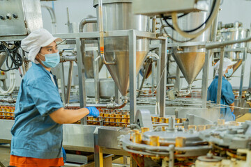 A factory worker inspects advanced machinery in a modern food production facility, ensuring seamless operations and compliance with hygiene and safety standards for efficient manufacturing processes.
