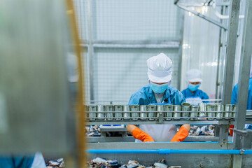 Skilled technician in a food factory handling canned products, highlighting efficiency, strict hygiene, and quality assurance in the food processing industry.