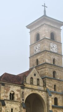 Front view of the Saint Michael Cathedral in Alba Iulia, Romania on a foggy weather. Vertical