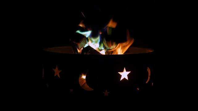Bonfire fire pit with sky stars cutouts at night camping. Beautiful flame with different color. High quality 4k footage
