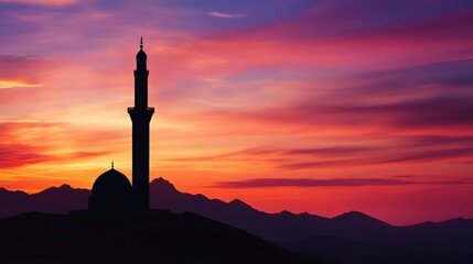A silhouette of a mosque against a colorful sunset over mountains.