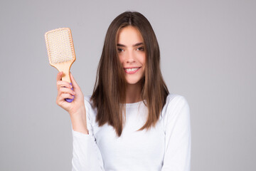 Young woman with hair comb in studio.