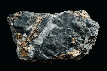 Dark gray rock with gold and white mineral deposits isolated on black background.