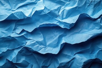 Fototapeta premium Crinkled blue paper creates a textured backdrop for various creative projects and designs in artistic settings