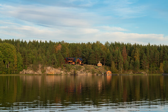 Wooden log house and chapel on the shore of Lake Ladoga near the village of Lumivaara on a sunny autumn day, Ladoga skerries, Lahdenpohya, Republic of Karelia, Russia