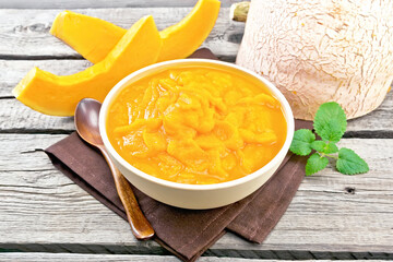 Pumpkin puree in bowl on old wooden board
