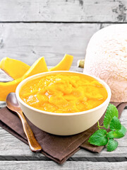 Pumpkin puree in bowl on wooden board