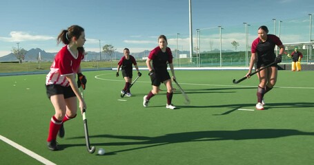 Female hockey players competing intensely on outdoor field, focused on game - Powered by Adobe