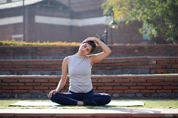 Pretty Woman Doing Seated Neck Stretches Exercise