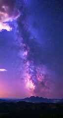 Naklejka premium Milky Way galaxy over mountain range at night.