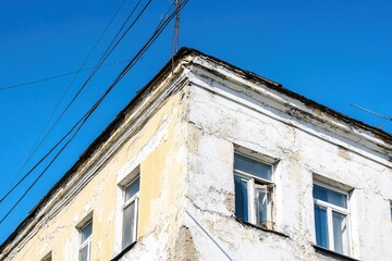 Dilapidated Corner Building Under Bright Blue Sky with Power Lines