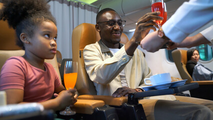 Father and Daughter Receiving In-Flight Beverage Service While Traveling on Airplane. Family Travel, Comfort and Professional Hospitality During Relaxing Flight Experience.