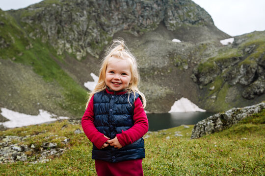 Child girl hiking in mountains family vacations travel active lifestyle adventure, 3 years old kid portrait happy smiling outdoor