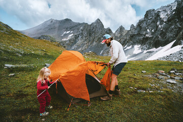 Family travel camping in mountains - father and child setting up tent camping gear, dad and kid hiking together active summer vacations outdoor adventure trip eco tourism healthy lifestyle