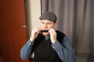 Man playing the harmonica, acoustic performance using hands and mouth, musician in rhythmic harmony with instrument