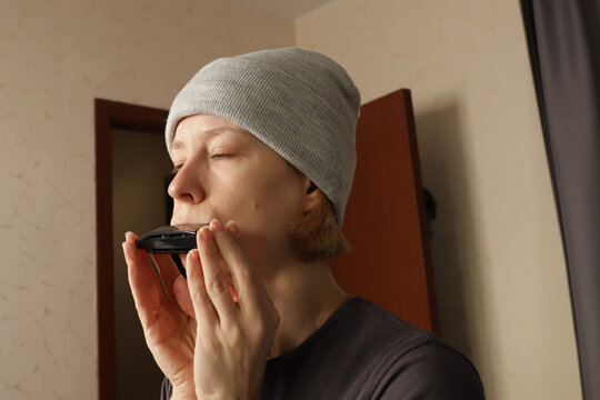 Harmonica lessons, woman playing musical instrument at home, silver harmonica for folk performance, musician’s cap and lifestyle in acoustic sound practice.