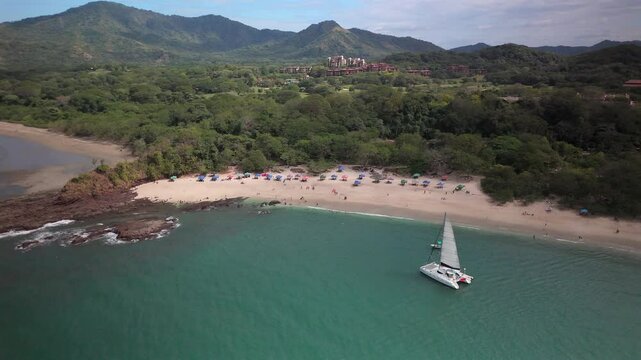 Sliding aerial view of a Catamaran docked off of Conchal Beach in Costa Rica