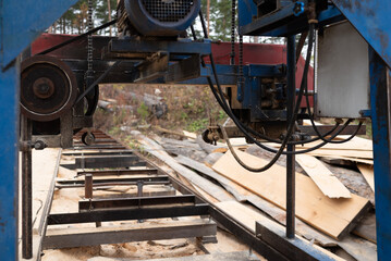 Close-up of machine for sawing pine logs at sawmill