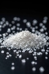 Coarse salt crystals scattered on a dark surface showcasing their natural texture and form