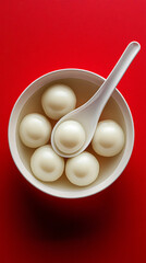 An image of a bowl of tangyuan on a solid color background