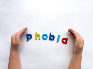 Fototapeta premium Colorful letters forming the word phobia with hands on a white background