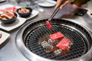  Fresh slices of beef cooking on yakiniku grill