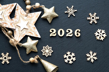 Happy New Year-wooden letters and the numbers 2026 on festive black background with sequins, stars, snow. Greetings, postcard. Calendar, cover