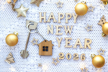 House key with keychain cottage on festive background with stars, lights of garlands. New Year 2026 wooden letters, greeting card. Purchase, construction, relocation, mortgage, insurance